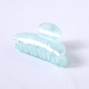 Detail view of a light blue pearlescent hair claw clip with acetate finish and smooth teeth