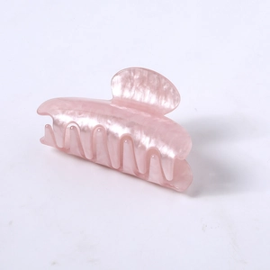 Macro detail of pearlescent pink acetate hair claw clip with smooth rounded teeth