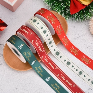 Set of four Christmas ribbons in red, white and green on a wooden tray with festive decor