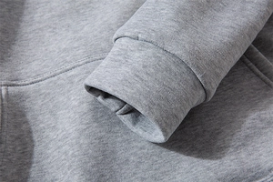 Detail of light gray knitted hoodie showing soft fabric texture and ribbed elastic cuff