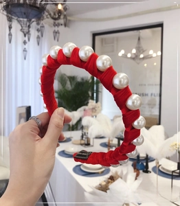 Detail of handmade red velvet headband with large pearls and Hand Made inner label