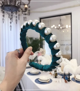 Detailed view of large white pearls on teal velvet wide headband for a vintage royal look
