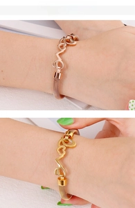 Close-up of gold and rose gold mesh Love bracelets with heart charms on model wrist
