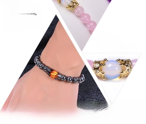 Macro detail of natural pink crystal and hematite bracelet with zircon crown charm