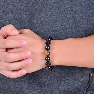 Macro detail of natural black agate and tiger eye stone beads on a wrist display