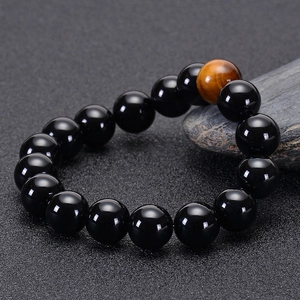 Macro shot of 10-12mm black onyx and tiger eye stone beads on a professional display