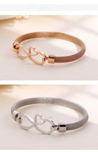Dettaglio del charm cuore infinito su bracciali a maglia intrecciata oro rosa e argento