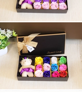 Detail of 12 soap roses and a plush bear in a black gift box with a gold ribbon