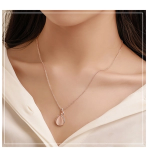 Dettaglio macro della collana in oro rosa con ciondolo opale rosa e pietre di zircone