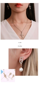 Dettaglio del set di gioielli con collana a croce, ciondolo a cuore e orecchini di perle