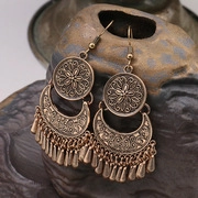 Détail macro de boucles d'oreilles vintage en bronze avec franges sur support céramique