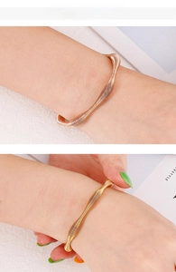 Detail of rose gold and gold spiral textured open bangles with wavy design for women