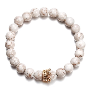 Natural white turquoise bead bracelet with a gold crown accent on white background