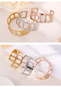 Detail of hollow geometric metal bangle with inlaid white zircons in three colors