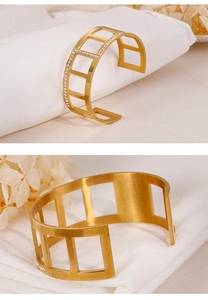 Detailed macro view of gold hollow geometric staircase bangle with sparkling crystals