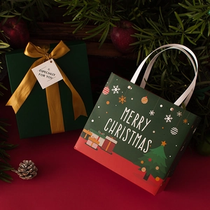 Christmas gift set with green paper bag and ribbon box among pine branches and red apples