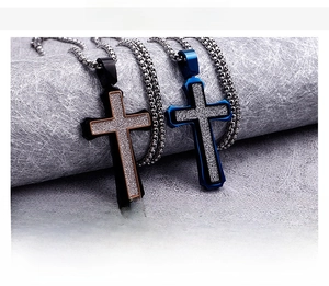 Close-up of titanium steel cross pendants in black and blue with shiny silver glitter inlay