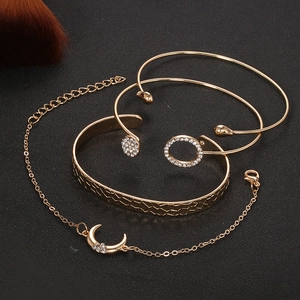 4-piece gold bracelet set with crystal moon charm, ring detail, and textured metal cuffs