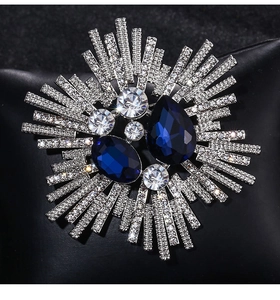 Macro detail of vintage sunburst brooch with navy crystals and sparkling rhinestones