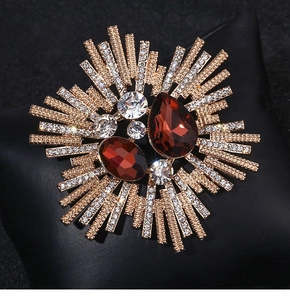 Macro detail of vintage floral brooch with deep red crystals and radiating diamond accents