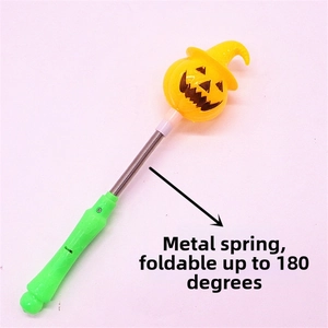 Detail of Halloween pumpkin wand showing flexible metal spring and 180-degree folding function