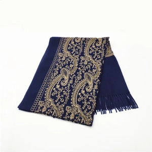Close-up of dark blue cashmere-like scarf with gold paisley embroidery and tassels