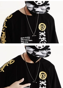 Gros plan d'un mannequin portant un collier haltère en argent sur un t-shirt imprimé noir