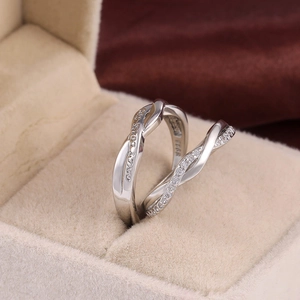 Macro shot of silver couple rings with Her King His Queen engraving in a jewelry box