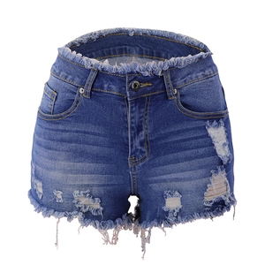 Detail view of frayed hem and distressed ripped texture on dark blue denim shorts