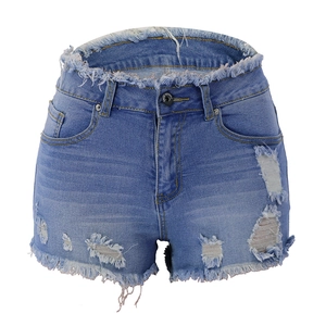 Detail of blue ripped denim shorts with distressed fraying and tassel hem