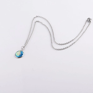 Detailed view of 12mm round ocean scale pendant on stainless steel silver chain