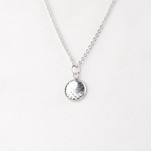 Macro shot of 12mm stainless steel necklace featuring a hammer-textured fish scale pendant