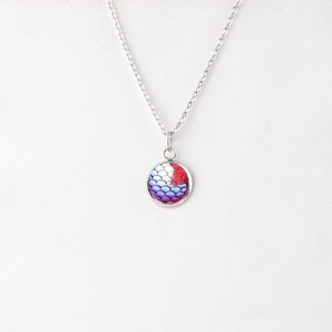 Detailed macro view of 12mm round mermaid scale pendant with iridescent pink and blue hues