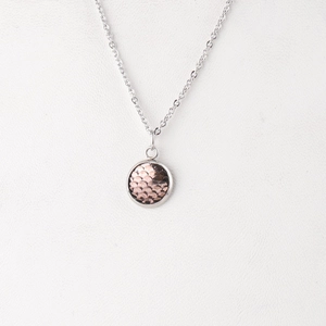 Macro shot of 12mm stainless steel necklace featuring a textured rose gold fish scale pendant