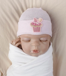 Close-up of baby knit beanie featuring pink striped patterns and a cupcake embroidery patch