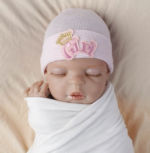 Close-up of pink striped knit baby hat featuring embroidered Girl text and gold crown