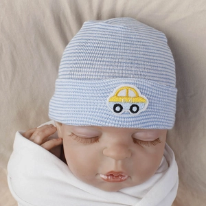 Detail of baby knit hat with blue stripes and a yellow car embroidery patch