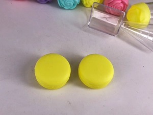 Top view of two yellow macaron-shaped cosmetic jars for creams and lip balms