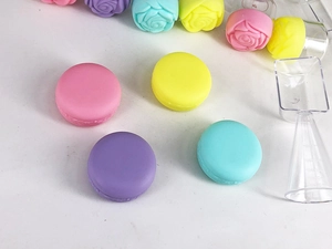 Macro shot of macaron and rose shaped cream jars with scoops and measuring cups