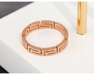 Detail shot of rose gold titanium ring with Greek Greca hollow pattern on display
