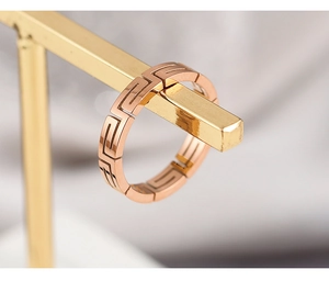 Macro view of rose gold titanium steel ring with hollow Greek key fret pattern details