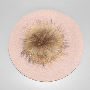 Top view of pink knitted wool beret featuring a large fluffy brown fur pompom on top