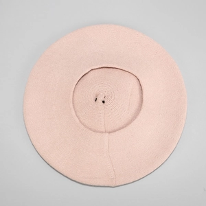 Detailed top view showing light pink wool knit texture of a cozy winter beret hat