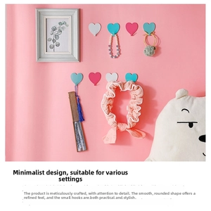 Detail of heart-shaped wall hooks holding jewelry and accessories in a cozy room
