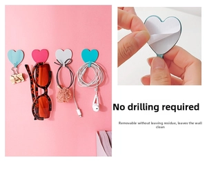 Detail of heart-shaped wall hooks showing peel-and-stick adhesive back for easy mounting