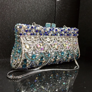 Detail of luxury rhinestone evening clutch with blue crystal scales and silver chain