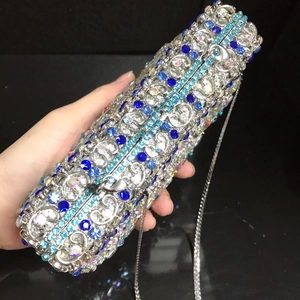 Detailed close-up of hollow silver metal evening bag with blue and iridescent crystals