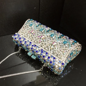 Detail of silver evening clutch bag with blue crystal fish scale pattern and metal chain