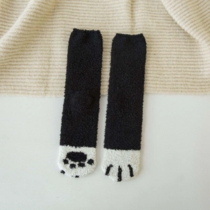 Detailed view of thick coral fleece winter socks featuring a cute black and white cat paw design