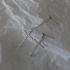 Asymmetric S925 silver cross earrings with sparkling zircons on white paper background